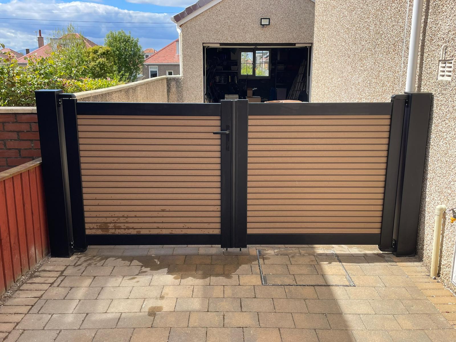 Composite double gate with black aluminium frame and timber-effect panels