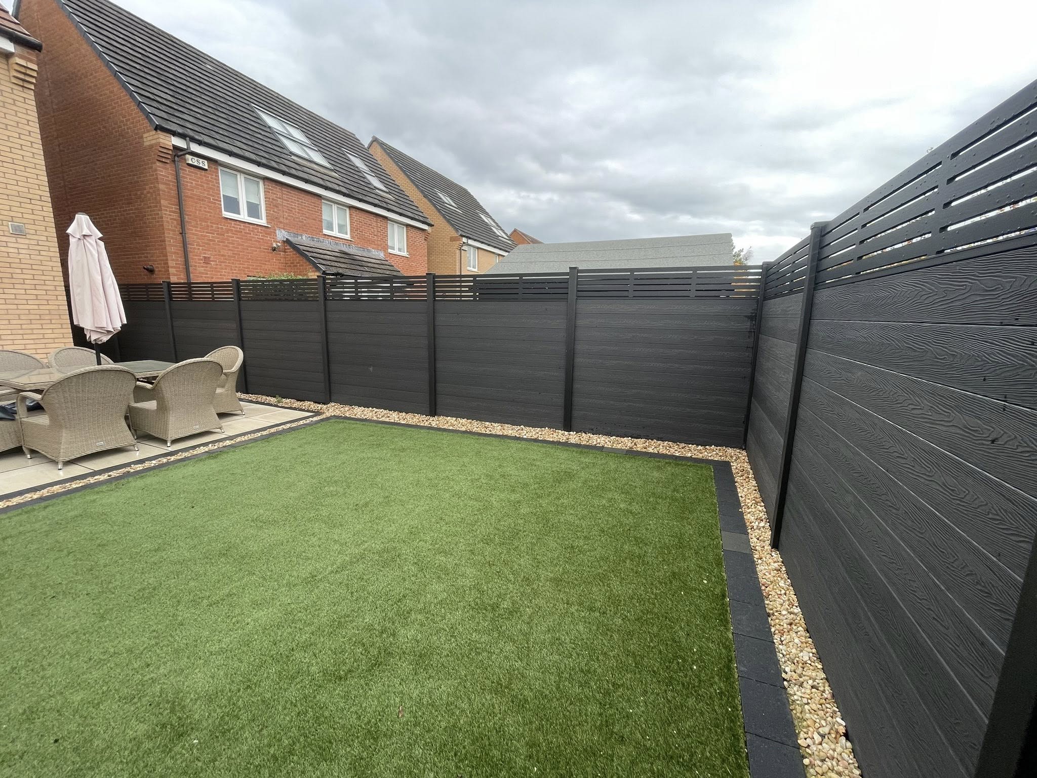 47m of composite fencing with 2 bespoke gates featuring dark grey slats, black composite and aluminium posts, black trellis, trims and caps in Ayrshire