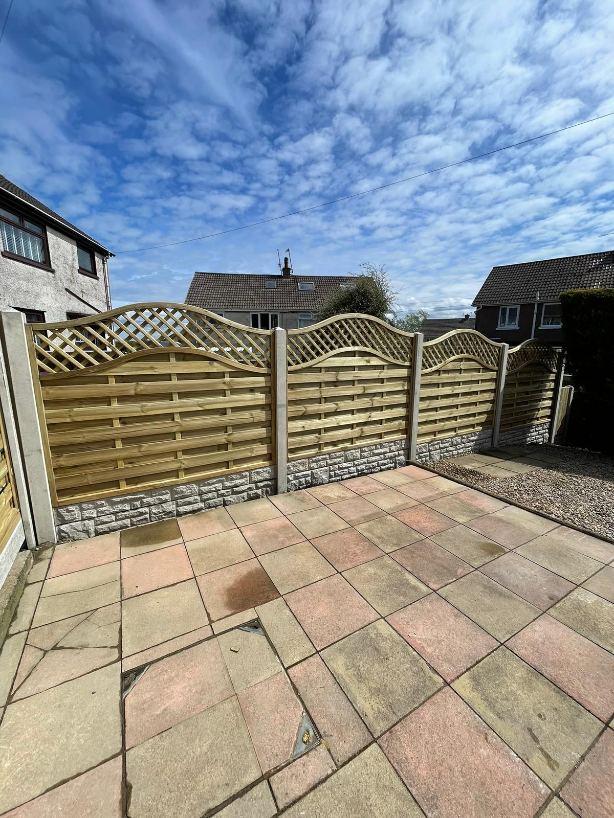 Decorative fence panels with curved lattice top on concrete gravel boards